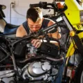 Mekanik sedang menerapkan cara mengatasi mesin motor sering mogok di bengkel