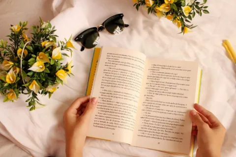 Seseorang menikmati waktu luang sambil membangun kebiasaan membaca buku di sudut kamar yang nyaman
