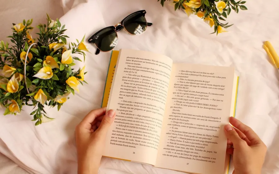 Seseorang menikmati waktu luang sambil membangun kebiasaan membaca buku di sudut kamar yang nyaman