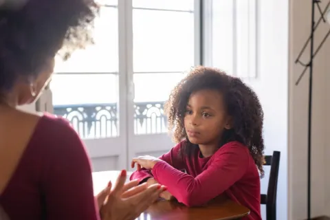Orang tua sedang berbicara lembut untuk mendisiplinkan anak tanpa kekerasan