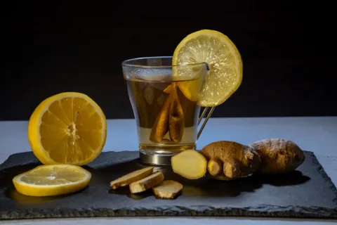 Seseorang sedang minum seduhan jahe hangat sebagai cara mengatasi asam lambung naik