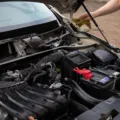 Mekanik sedang mengecek cara merawat aki mobil agar awet dan bebas tekor di bengkel