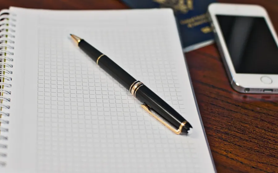 Buku jurnal dan pulpen di atas meja untuk menerapkan ide journaling untuk pemula yang fungsional