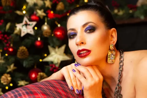 Wanita mengaplikasikan riasan mata hangat sebagai ide makeup untuk acara pesta malam