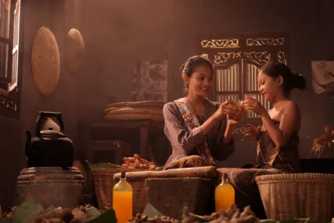 Sajian minuman sehat penambah imun hangat dari jahe, lemon, dan madu di atas meja kayu