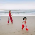 Keluarga bahagia sedang menikmati ide liburan keluarga yang seru di tepi pantai