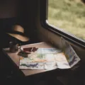 Ilustrasi menyusun itinerary perjalanan liburan dengan peta digital dan catatan rencana perjalanan di kafe
