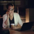 Pekerja kantor menutup laptop saat jam kerja selesai sebagai tips menjaga work life balance