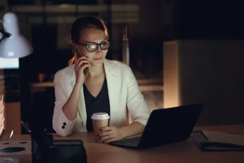 Pekerja kantor menutup laptop saat jam kerja selesai sebagai tips menjaga work life balance
