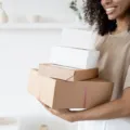 Pemilik usaha menyiapkan kemasan paket rapi sebagai langkah penerapan cara membangun reputasi bisnis yang tepercaya
