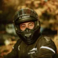 Pengendara motor sedang mempraktikkan cara memilih helm yang aman dan nyaman sebelum berkendara di jalan raya