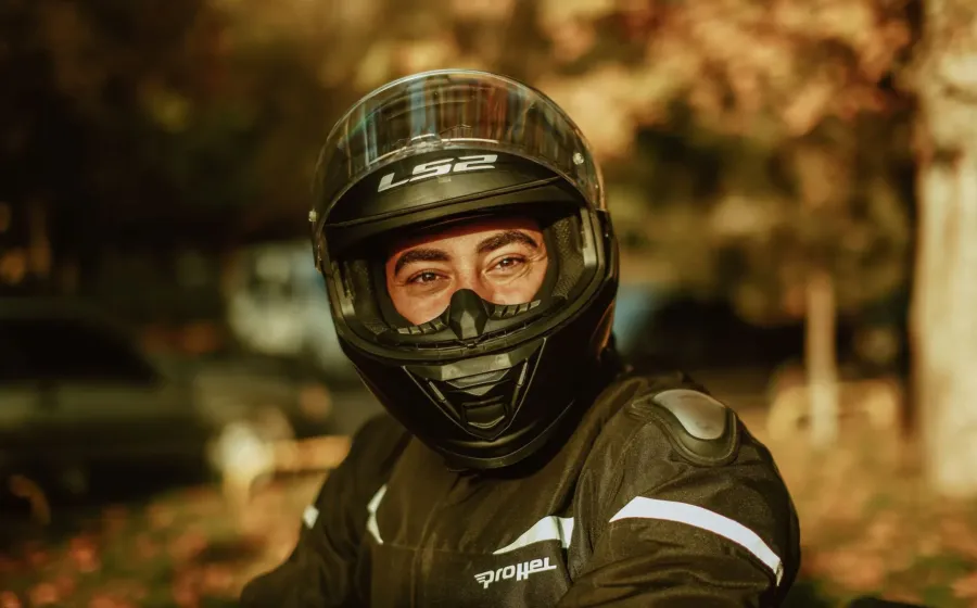 Pengendara motor sedang mempraktikkan cara memilih helm yang aman dan nyaman sebelum berkendara di jalan raya