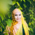 Wanita mengenakan hijab voal berwarna hangat yang serasi dengan warna kulit wajah