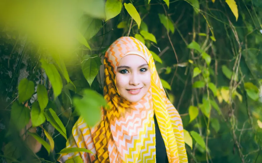 Wanita mengenakan hijab voal berwarna hangat yang serasi dengan warna kulit wajah