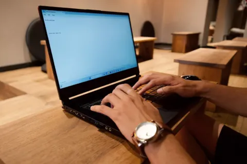 Seseorang sedang bekerja fokus di depan laptop sebagai cara mengatasi rasa malas