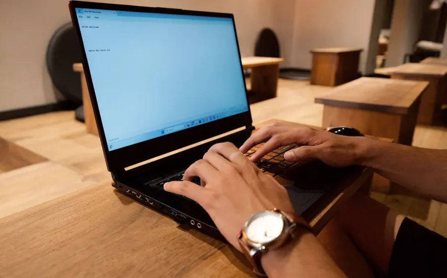 Seseorang sedang bekerja fokus di depan laptop sebagai cara mengatasi rasa malas
