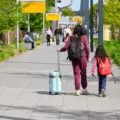 Orang tua dan balita menyiapkan tas kabin saat menerapkan cara traveling dengan anak kecil yang praktis