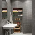 Ide desain kamar mandi minimalis dengan dinding keramik terang dan cermin bulat tanpa bingkai