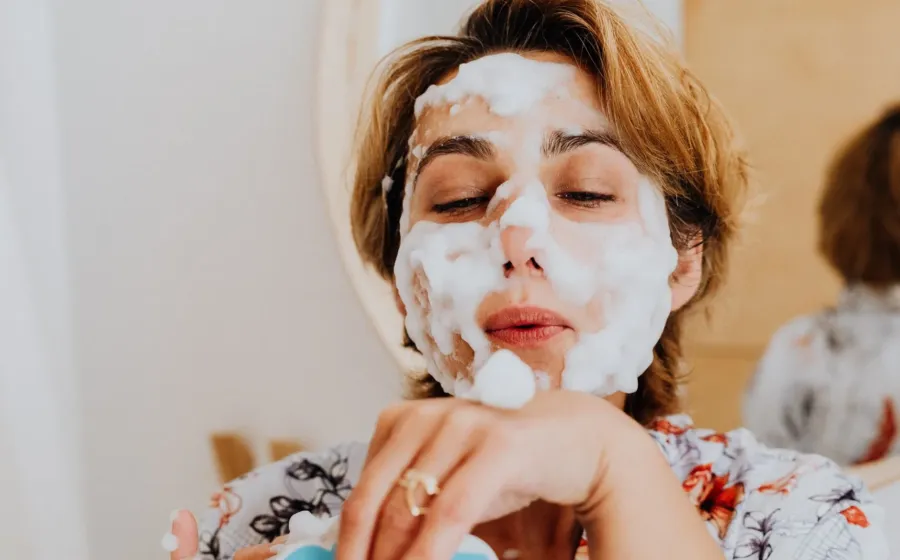 Wanita sedang mengusapkan micellar water ke wajah sebagai tahapan ide double cleansing yang benar