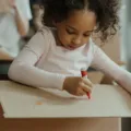 Anak membuat kerajinan tangan dari kardus bekas sebagai ide kegiatan kreatif untuk anak di rumah
