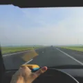 Seseorang sedang memegang setir mobil di jalan tol untuk tips berkendara jarak jauh yang aman