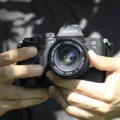 Seseorang sedang memegang bodi mirrorless ringkas sebagai panduan tips memilih kamera untuk pemula