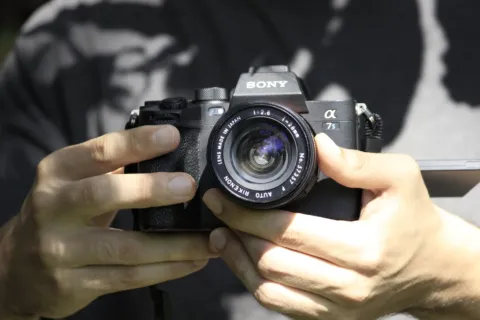 Seseorang sedang memegang bodi mirrorless ringkas sebagai panduan tips memilih kamera untuk pemula