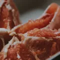 Piring berisi sayuran hijau dan buah segar untuk mendukung tips menjaga kesehatan pencernaan harian