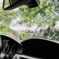 Proses membersihkan kaca depan mobil menggunakan kain mikrofiber agar bersih bebas jamur