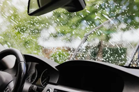 Proses membersihkan kaca depan mobil menggunakan kain mikrofiber agar bersih bebas jamur